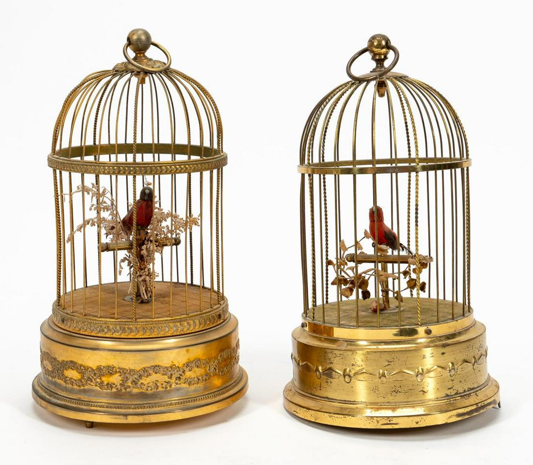 2 PCS, AUTOMATONS, INCLUDING KARL GRIESBAUM: Continental, 20th century. Caged bird automaton in gilt metal cage with scrolling floral and foliate design along base containing red feathered bird on perch with dried vegetation, marked "Made in Fra