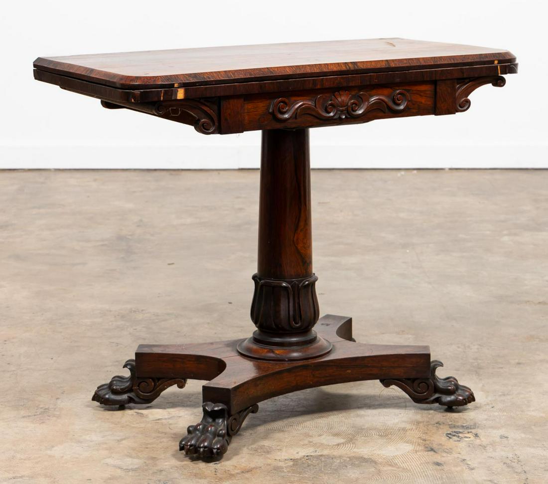 REGENCY ROSEWOOD GAMES TABLE, C. 1820: English, circa 1820. Regency era rosewood games table having a flip-top, shell decorated frieze, acanthus patterned pedestal, and rising on a four-part base with paw feet. Unmarked. Approx. h. 29.5", 