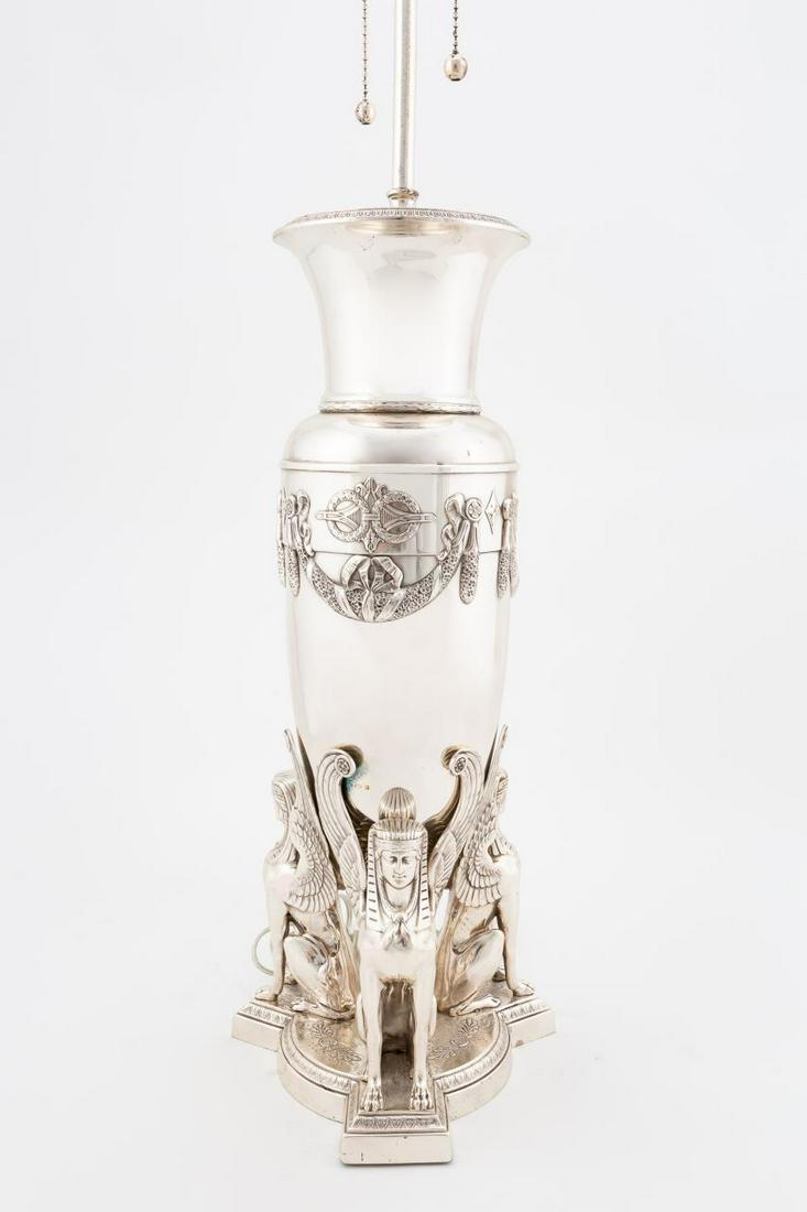19TH C. SILVERPLATED BRONZE EGYPTIAN REVIVAL LAMP: English, circa 1860. Silverplated bronze Egyptian revival amphora form urn or vase, now mounted as a table lamp, the body with floral swags, and supported by three sphinxes on a tripartite base, with 