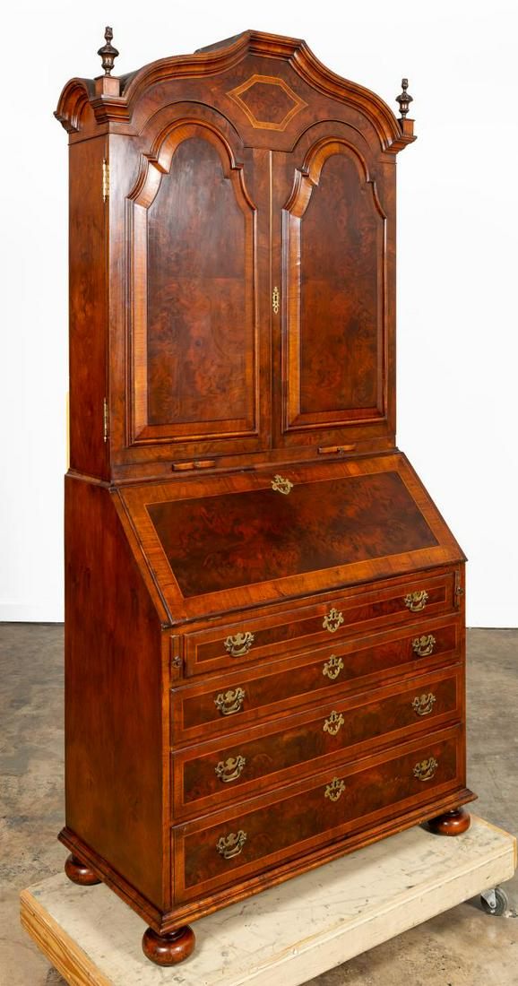 ENGLISH QUEEN ANNE STYLE BURL WALNUT BUREAU DESK: English, early 20th century. Burl walnut bureau desk in the Queen Anne taste in two parts, having an arched hood with finials, candleslides, double blind paneled doors that open to reveal an interior