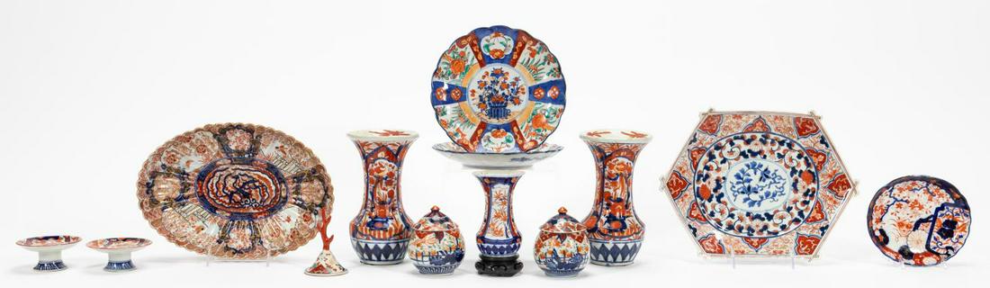 13 PIECES, JAPANESE IMARI PORCELAIN TABLEWARE: Japanese. Group of thirteen items of Imari patterned tableware comprising a scalloped bowl with gilt accents, hexagonal platter, pair of scalloped plates, oval scalloped dish, pair of small footed dis