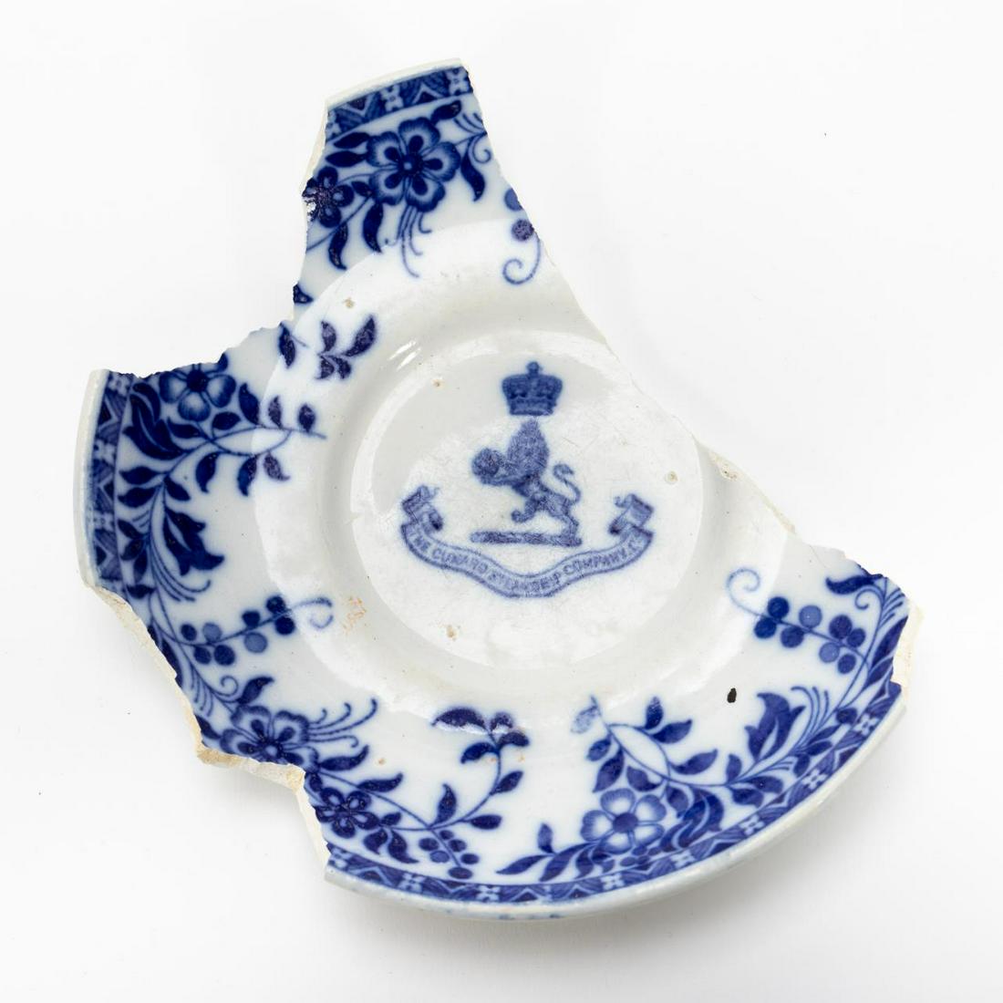 RMS CARPATHIA, SALVAGED FIRST CLASS PARTIAL SAUCER: RMS Carpathia, Cunard Line, maiden voyage May 5, 1903; sunk July 15, 1918. Salvaged first class Mintons 'Ormond' pattern blue and white floral partial pottery saucer with Cunard Line logo. Stamped to 