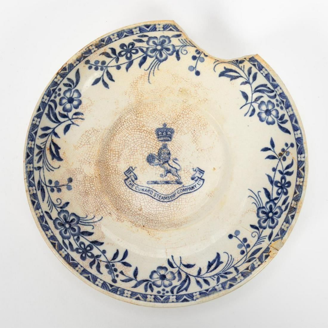 RMS CARPATHIA, SALVAGED FIRST CLASS SAUCER: RMS Carpathia, Cunard Line, maiden voyage May 5, 1903; sunk July 15, 1918. Salvaged first class Mintons 'Ormond' pattern blue and white floral pottery saucer with Cunard Line logo. Stamped to the bott