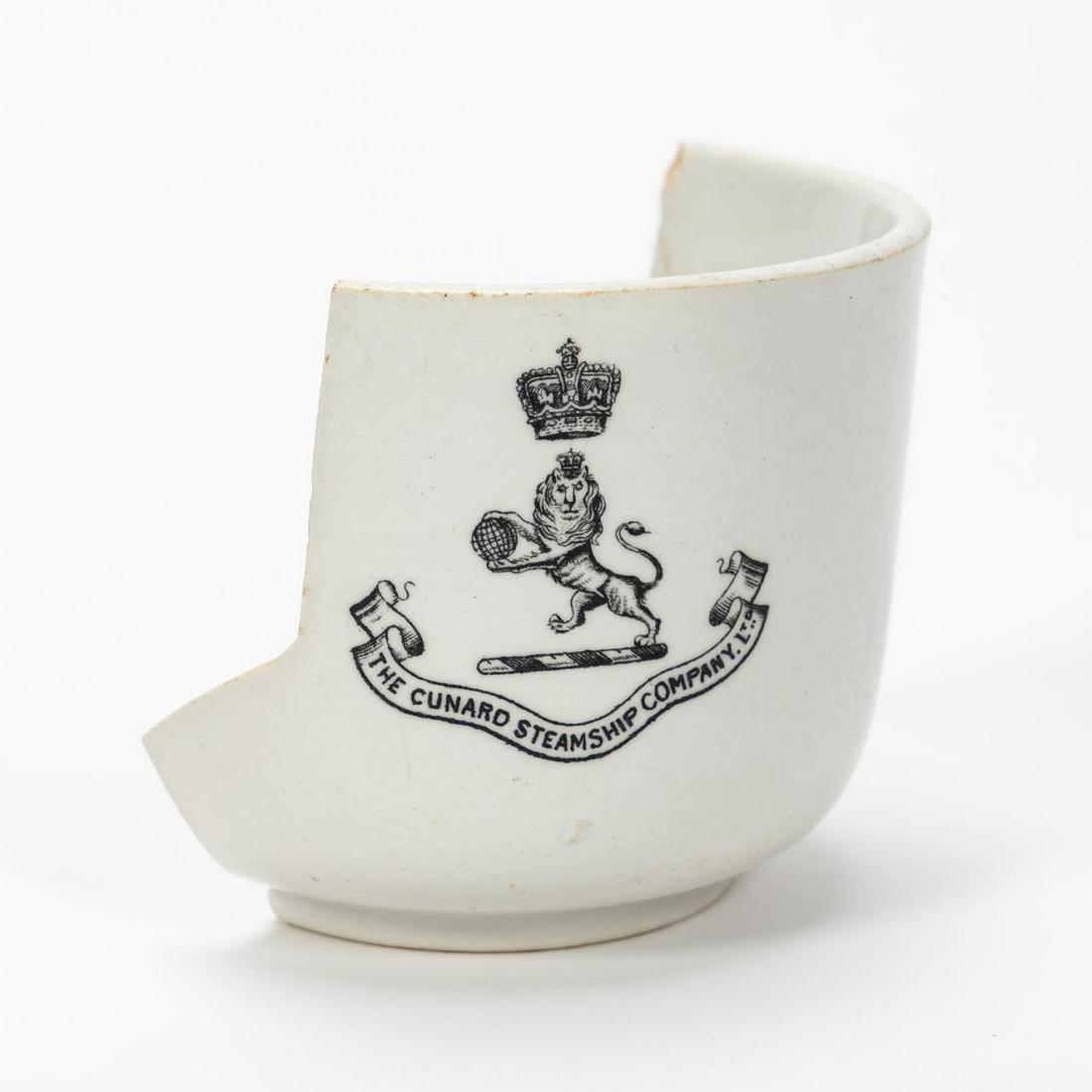 RMS CARPATHIA, SALVAGED PARTIAL THIRD CLASS CUP: RMS Carpathia, Cunard Line, maiden voyage May 5, 1903; sunk July 15, 1918. Salvaged partial white Mintons third class pottery cup with Cunard Line logo. This type of cup was also used on the RMS Lusit