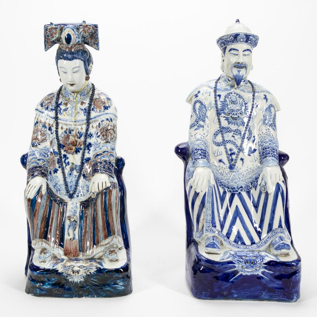 PAIR, CHINESE LG. SEATED EMPEROR & EMPRESS FIGURES: Chinese. Group of two large ceramic figures depicting a seated emperor with blue & white decoration and an empress with blue, white & rust decoration. The emperor with a Qing Qianlong type mark , the 