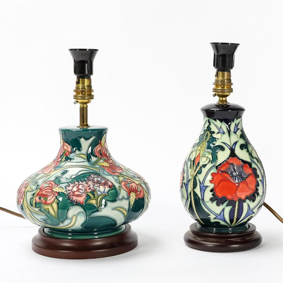 TWO MOORCROFT COLORFUL FLORAL MOTIF CERAMIC LAMPS: Moorcroft (English, est. 1897), 20th century. Group of two small squat table ceramic lamps with floral motif. Marked to underside. Approx. h. 12.25" (tallest, top of socket).