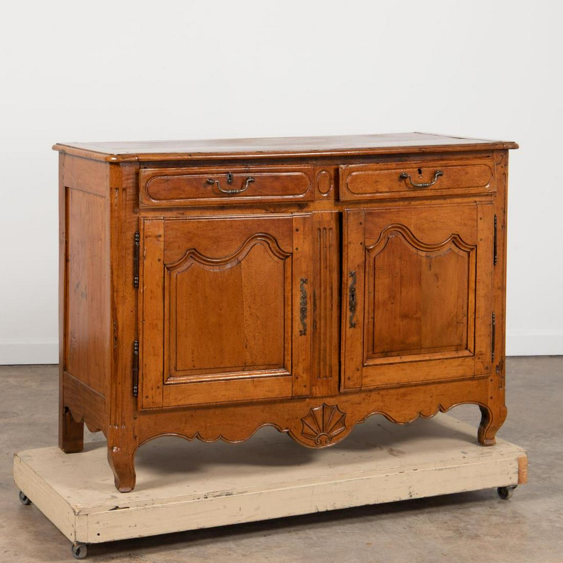 18TH C. FRENCH LOUIS XV PROVINCIAL BUFFET: French, 18th century. Provincial Louis XV carved cherry or fruitwood buffet having two drawers above double paneled doors, shell carved scalloped apron and rising on front cabriole legs. Unmarked. Pro