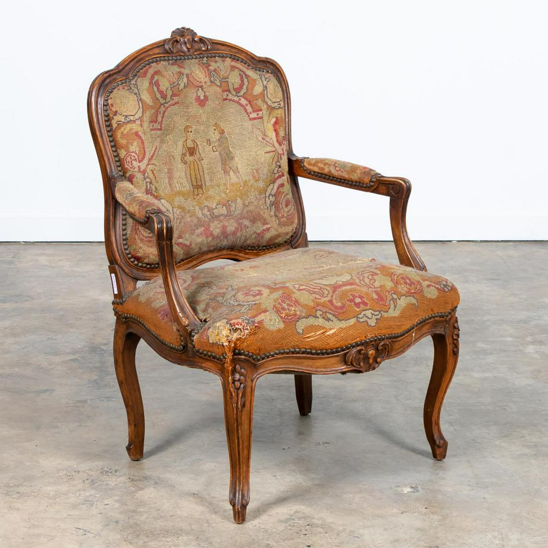 19TH C. LOUIS XV STYLE WALNUT FAUTEUIL: French, 19th century. Louis XV style walnut needlepoint armchair having figural and bird scene. Straw / natural fill. Apparently unmarked. Approx. h. 37.5", w. 25", d. 20".