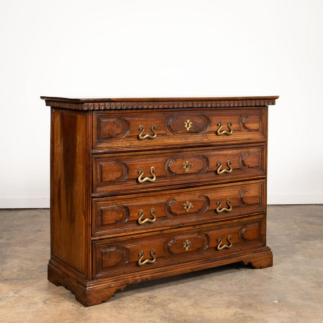 19TH C. ITALIAN BAROQUE STYLE FOUR-DRAWER CHEST: Italian, 19th century or earlier. Walnut chest or commode in the baroque taste having an overhanging top, dentil moulding, four paneled drawers, and rising on bracket feet. Unmarked. Provenance: From