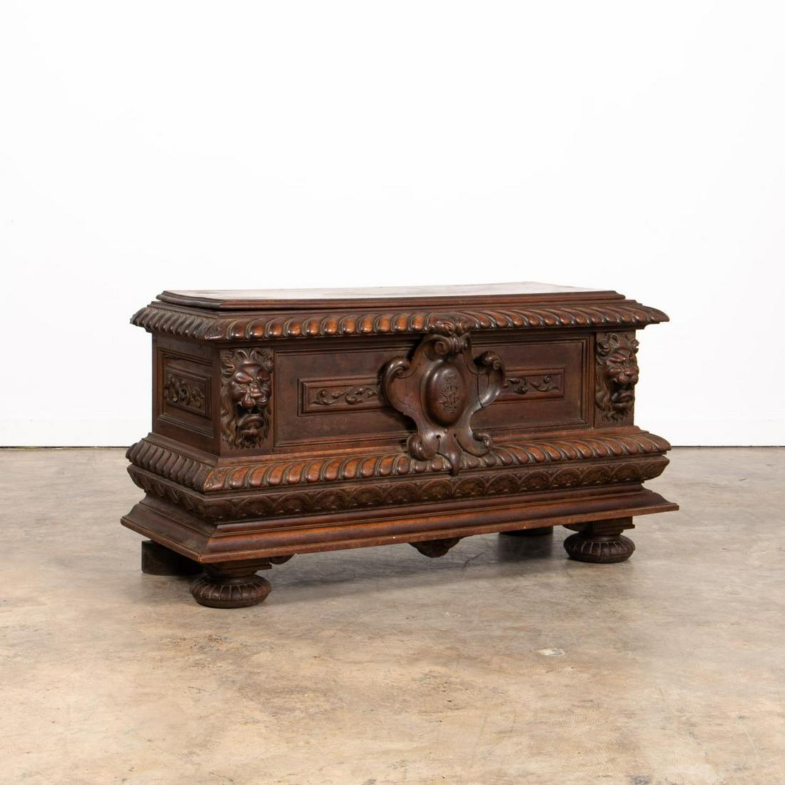 19TH C. RENAISSANCE REVIVAL CARVED WALNUT CASSONE: Continental, second half 19th century. Well carved walnut cassone or chest, having gadrooned edges, central monogrammed cartouche, floral panels flanked by lion's heads, and rising on fluted ball feet