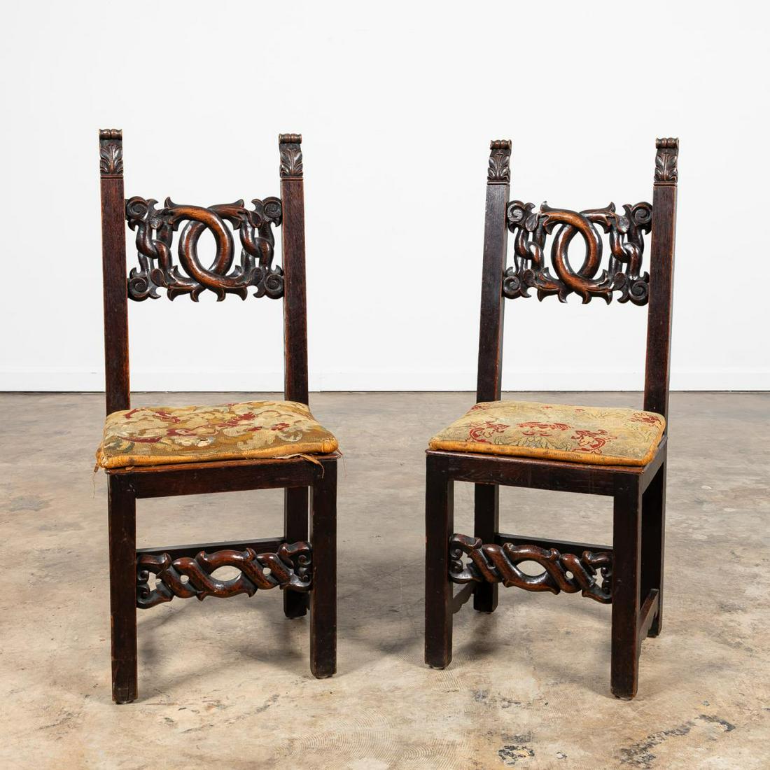 PR., CONTINENTAL BAROQUE REVIVAL SIDE CHAIRS: Continental, late 19th / early 20th century. Pair of walnut side chairs in the Italian-Spanish renaissance-baroque taste having foliate carved finials, scrolled pierced back rest and front stretcher, 