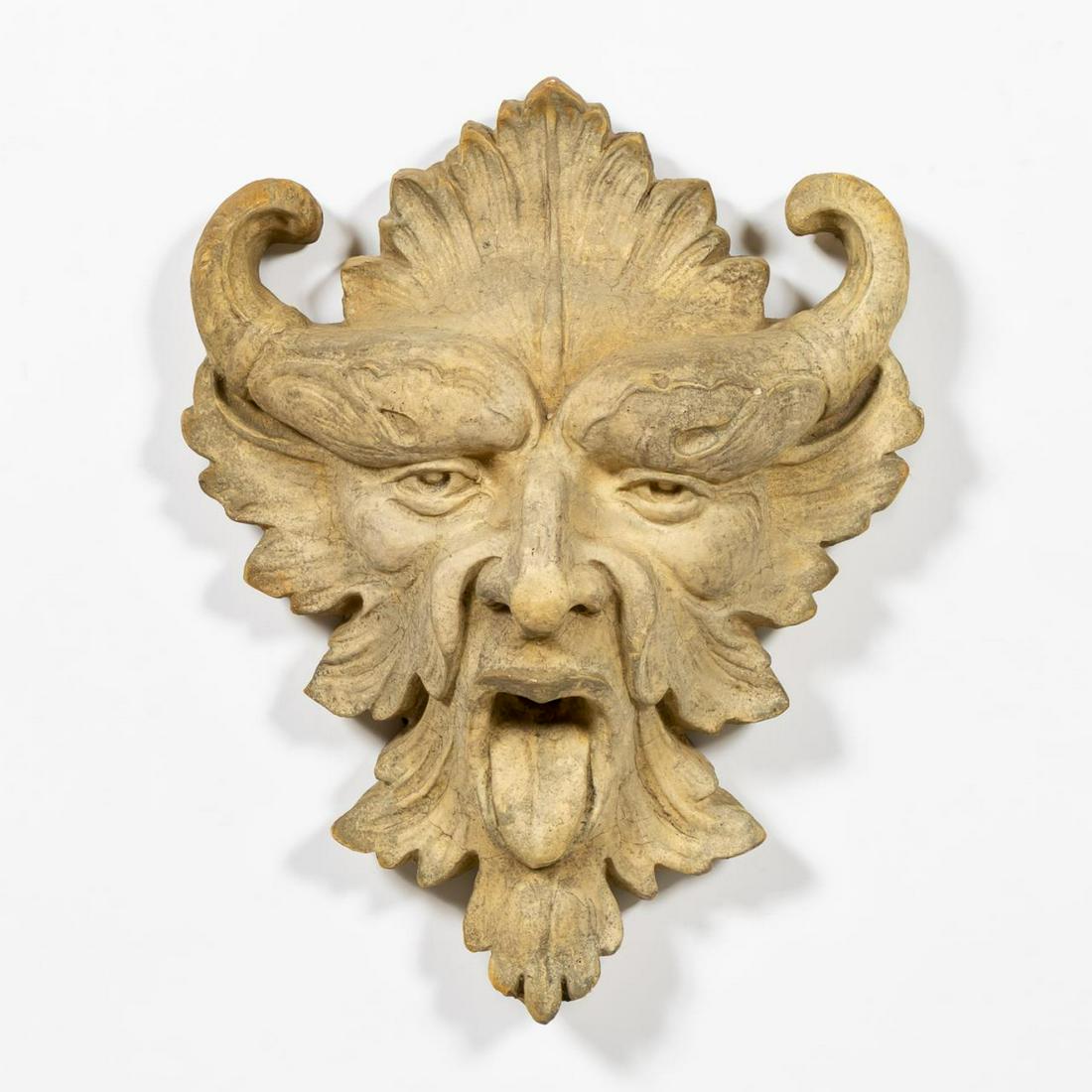 BAROQUE STYLE CAST STONE GREENMAN WALL MASK: Possibly Continental, contemporary. Cast stone greenman or grotesque garden wall mask in the baroque taste having an open mouth, his tongue extended. Unmarked. Approx. h. 4.5", w. 11", d. 13.5". Item 