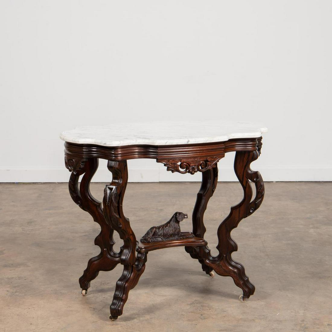 MANNER, H.N. WENNING MARBLE TOP DOG PARLOR TABLE: Manner of H.N. Wenning (American, 1869-1873), last quarter 19th century. Victorian era walnut parlor table with rosewood painted graining, having a white turtle form marble top, shaped and scrolled ap