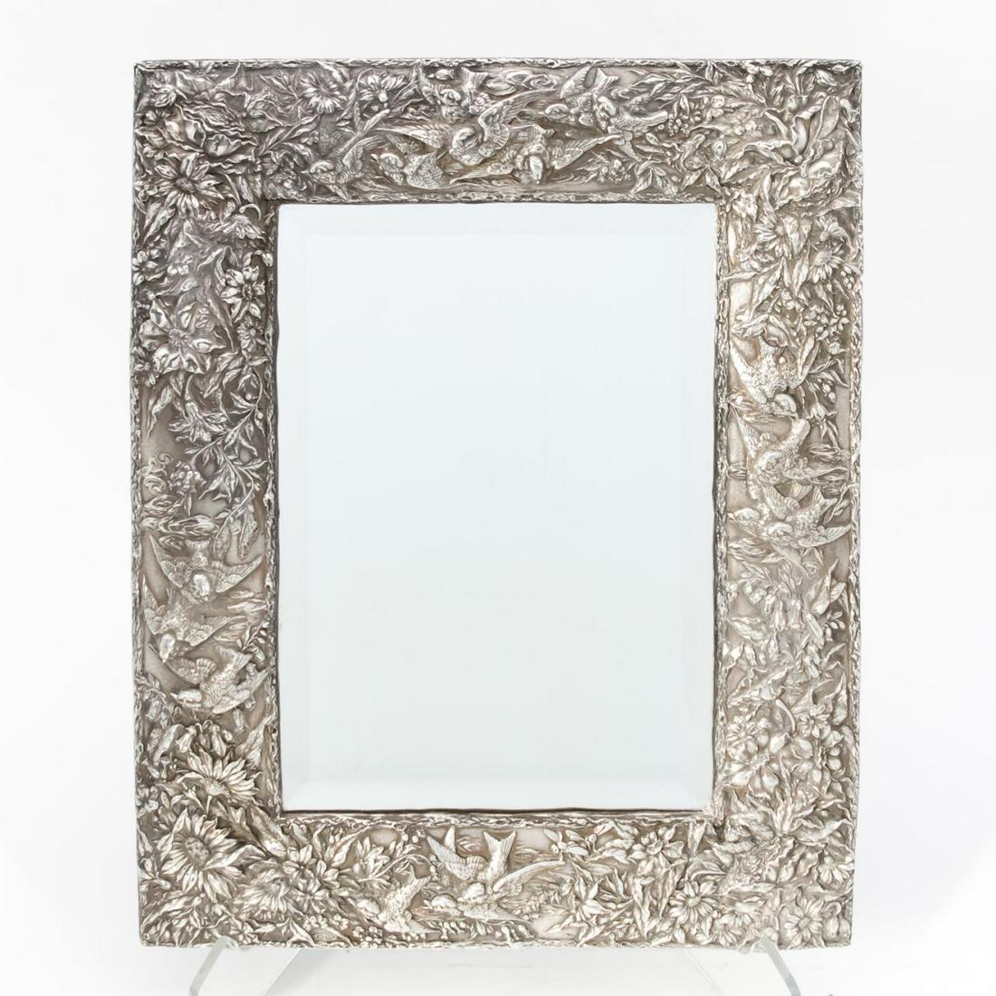 AMERICAN STERLING REPOUSSE BIRD MOTIF TABLE MIRROR: Jack Rabinovich (American, 20th century), contemporary. Large repousse sterling silver 'Springtime' dressing table mirror having a bird and floral motif with beveled mirror plate. Marked 'JR/925'. Pro