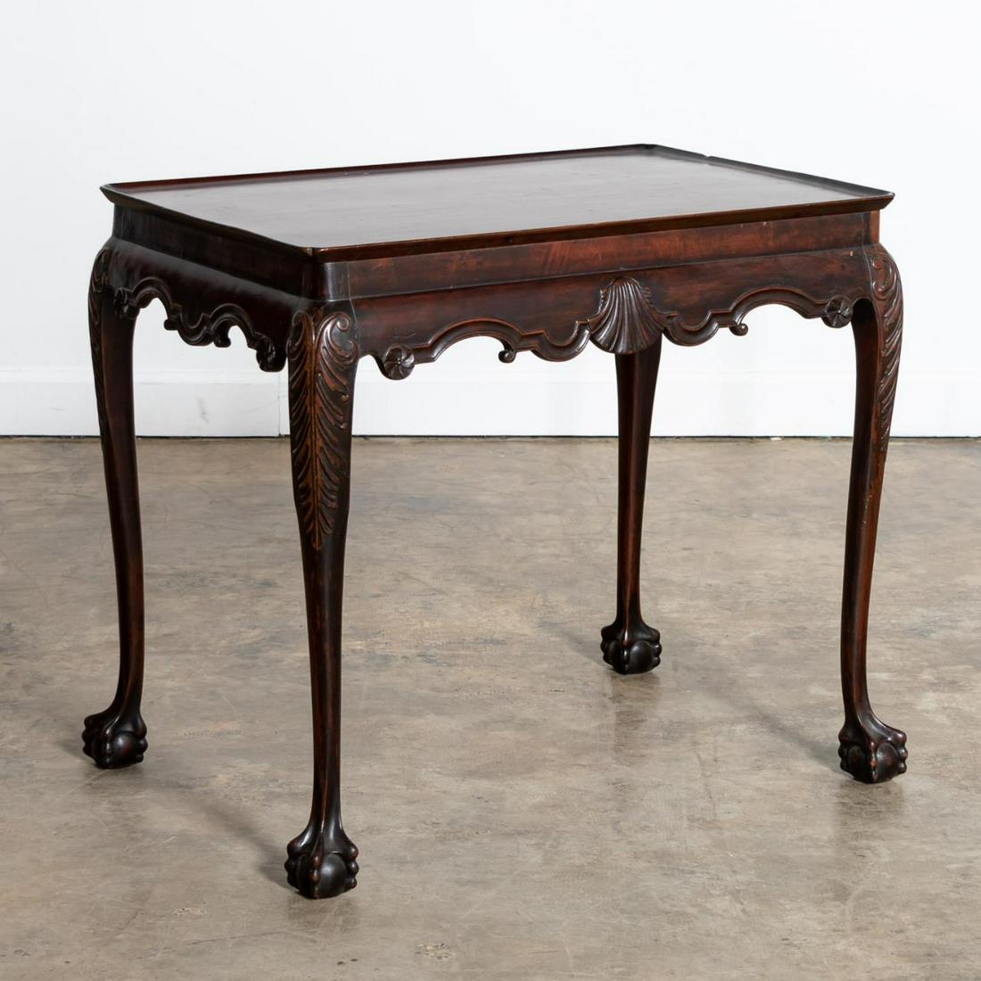 18TH C. IRISH MAHOGANY SILVER OR TEA TABLE: Irish, 18th century. Georgian silver or tea table having a dish or tray top, cyma form apron with shells and rosettes, and rising on acanthus carved cabriole legs with claw and ball feet. Unmarked. Pr
