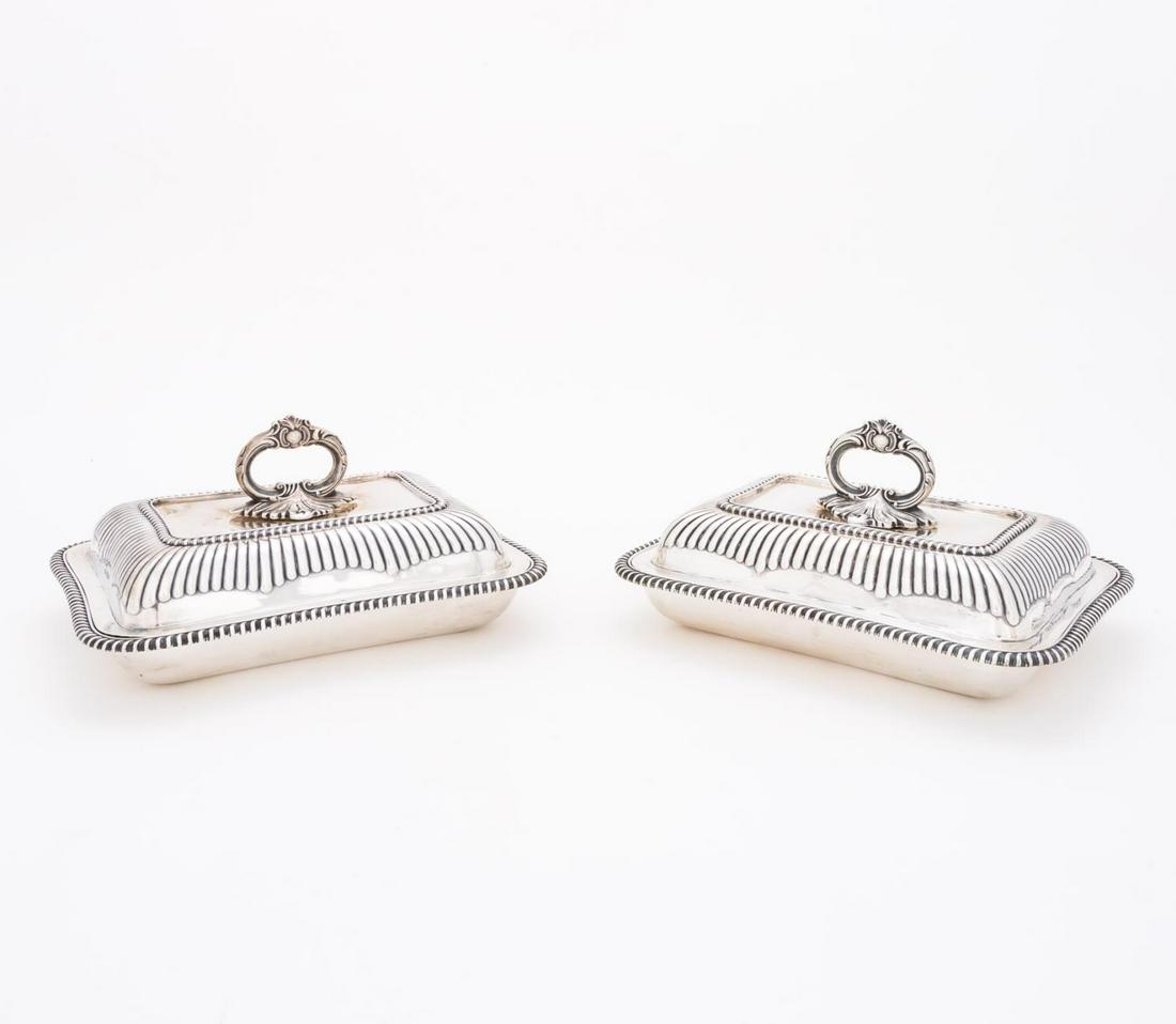PAIR ENGLISH SHEFFIELD STERLING ENTREE DISHES: Martin, Hall & Co (English), circa 1906. Pair of Edwardian lidded sterling silver entree dishes having "C" scroll handles and gadrooned decoration. Monogrammed "GG". Appropriately marked to both lid a