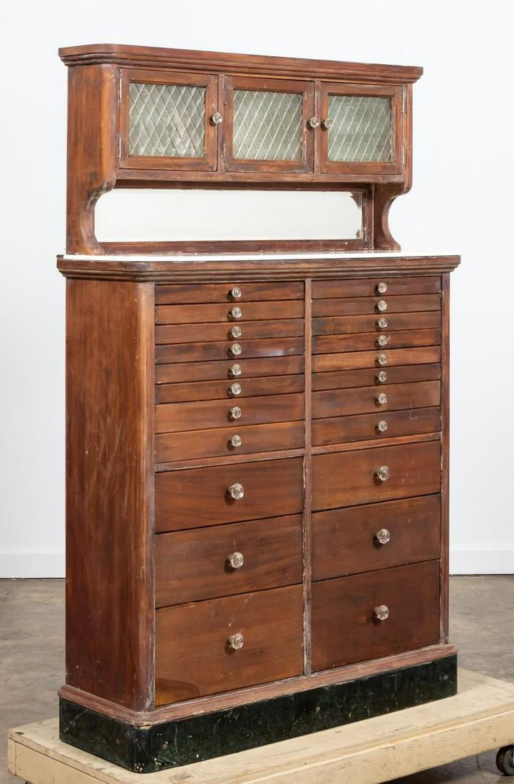 EARLY 20TH CENTURY AMERICAN DENTAL CABINET: American, early 20th century. Antique dental cabinet with twenty two drawers, glass front upper cabinet, and beveled mirror back. Apparently unmarked. Approx. h. 62.75", w. 40", d. 13.5"
