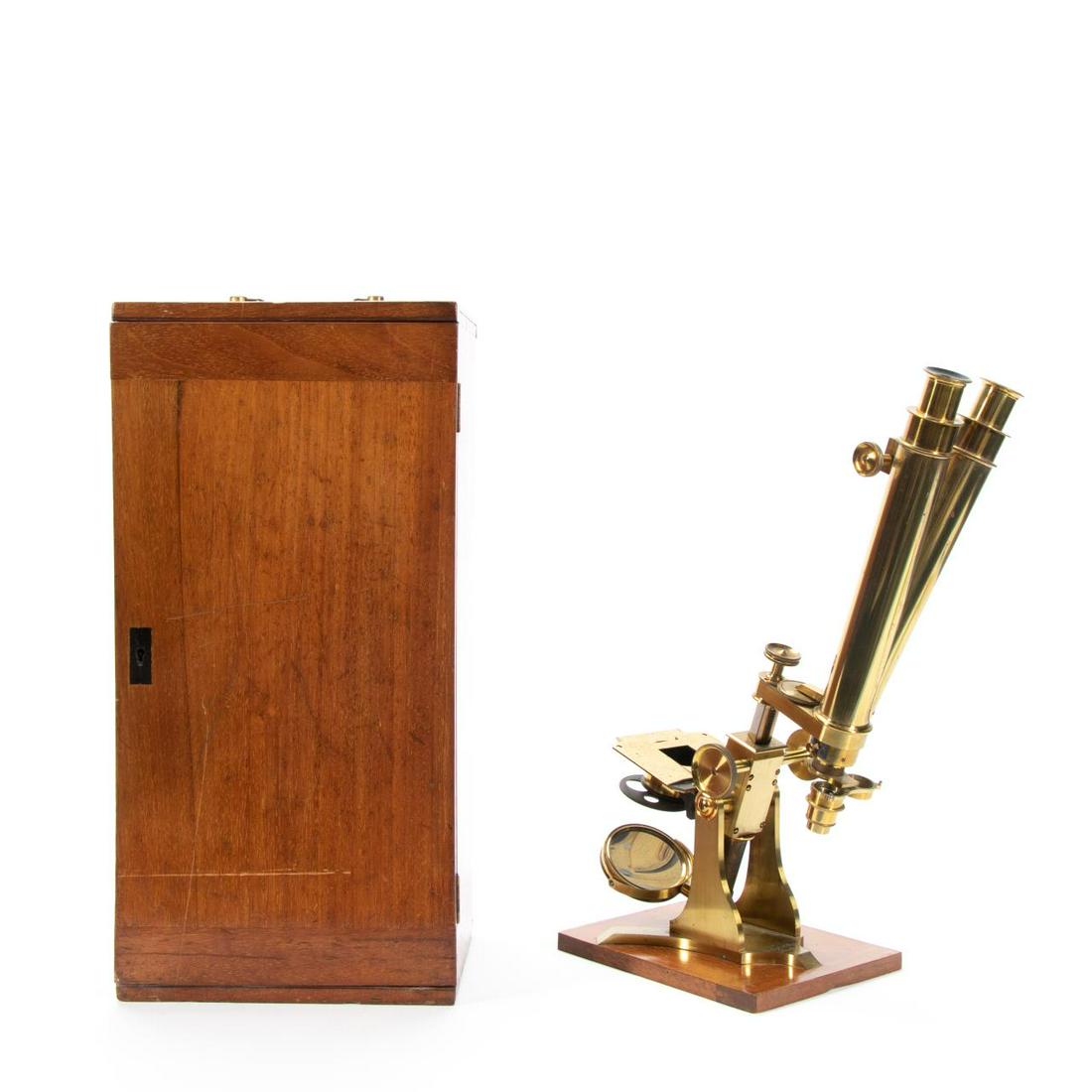 19TH C. CHARLES BAKER BINOCULAR MICROSCOPE IN CASE: Charles Baker (Active, London, 1851-1901), circa 1855. Lacquered binocular microscope, having dual brass tubes, square stage, gimbaled plano/concave mirror, and on a tripod base; with mahogany case an
