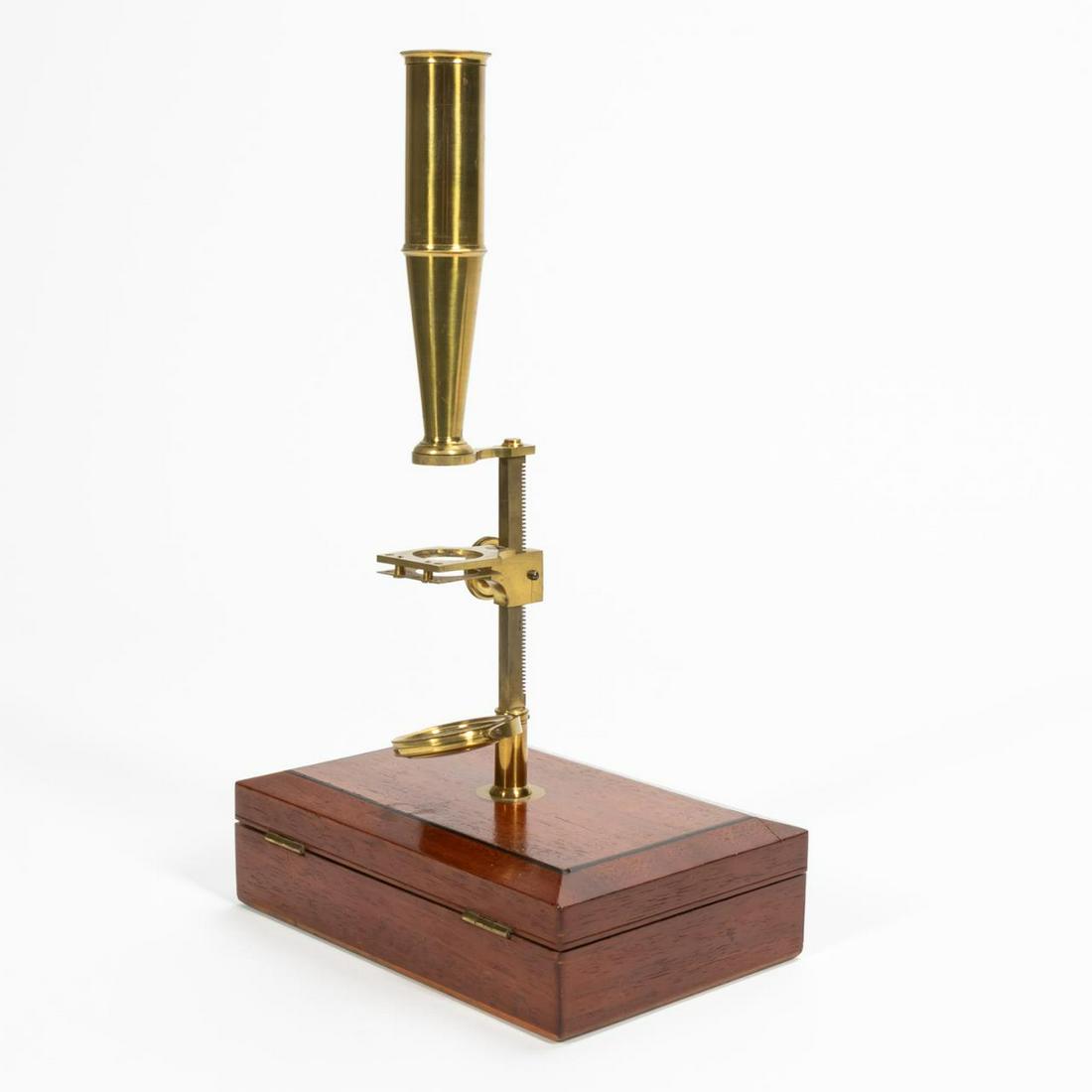 19TH C. GOULD TYPE COMPOUND MICROSCOPE IN CASE: English, mid-19th century. Monocular brass Gould/Cary-type compound microscope, having an adjustable arm, gimbaled plano/concave mirror, and in a mahogany case; together with an assortment of accessor