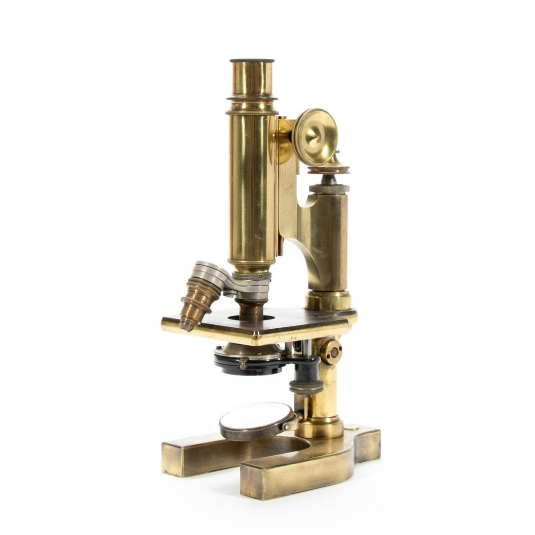 BAUSCH & LOMB BRASS MONOCULAR MICROSCOPE IN CASE: Bausch & Lomb (American, founded 1853), 1905. Lacquered monocular microscope, having brass tubes, double nosepiece, square stage, gimbaled plano/concave mirror, and on a Y-shaped base; with mahogany c