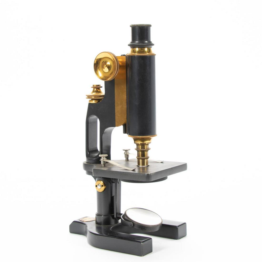 SPENCER LENS CO. IRON & BRASS MICROSCOPE IN CASE: Spencer Lens Co. (American, 1895-1945), 1914. Iron and brass monocular microscope, having a square stage, plano/concave mirror, and on a Y-shaped base; in original case with additional accessories and