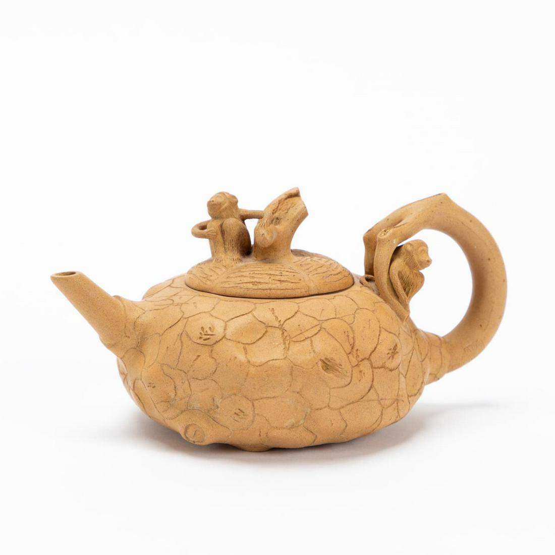 CHINESE YIXING ZISHA TAN MONKEY TEAPOT: Chinese. Yixing Zisha clay tan teapot having a gourd form body, the twig finial and handle decorated with monkeys. Marked to the interior of lid and underside. Approx. h. 3", w. 6", d. 4".