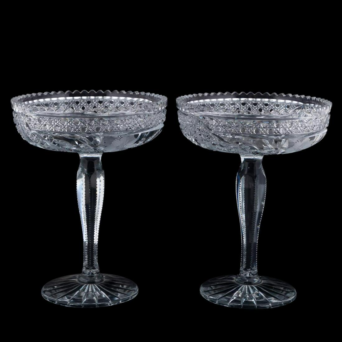 PAIR AMERICAN BRILLIANT PERIOD CUT GLASS COMPOTES: American, late 19th / second quarter 20th century. Pair of tall American Brilliant Period colorless cut glass compotes or tazzas having sawtooth rims, caned bands and copper wheel floral decoration. A