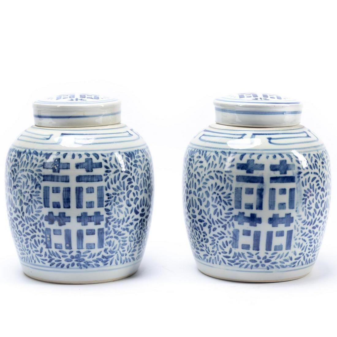 PAIR, CHINESE BLUE AND WHITE DOUBLE HAPPINESS JARS: Chinese. Pair of blue and white lidded "Double Happiness" pottery jars, having a foliate pattern. Blue double circle mark to the underside. Provenance: From the Estate of Aimee Lacey Champion of Fairm