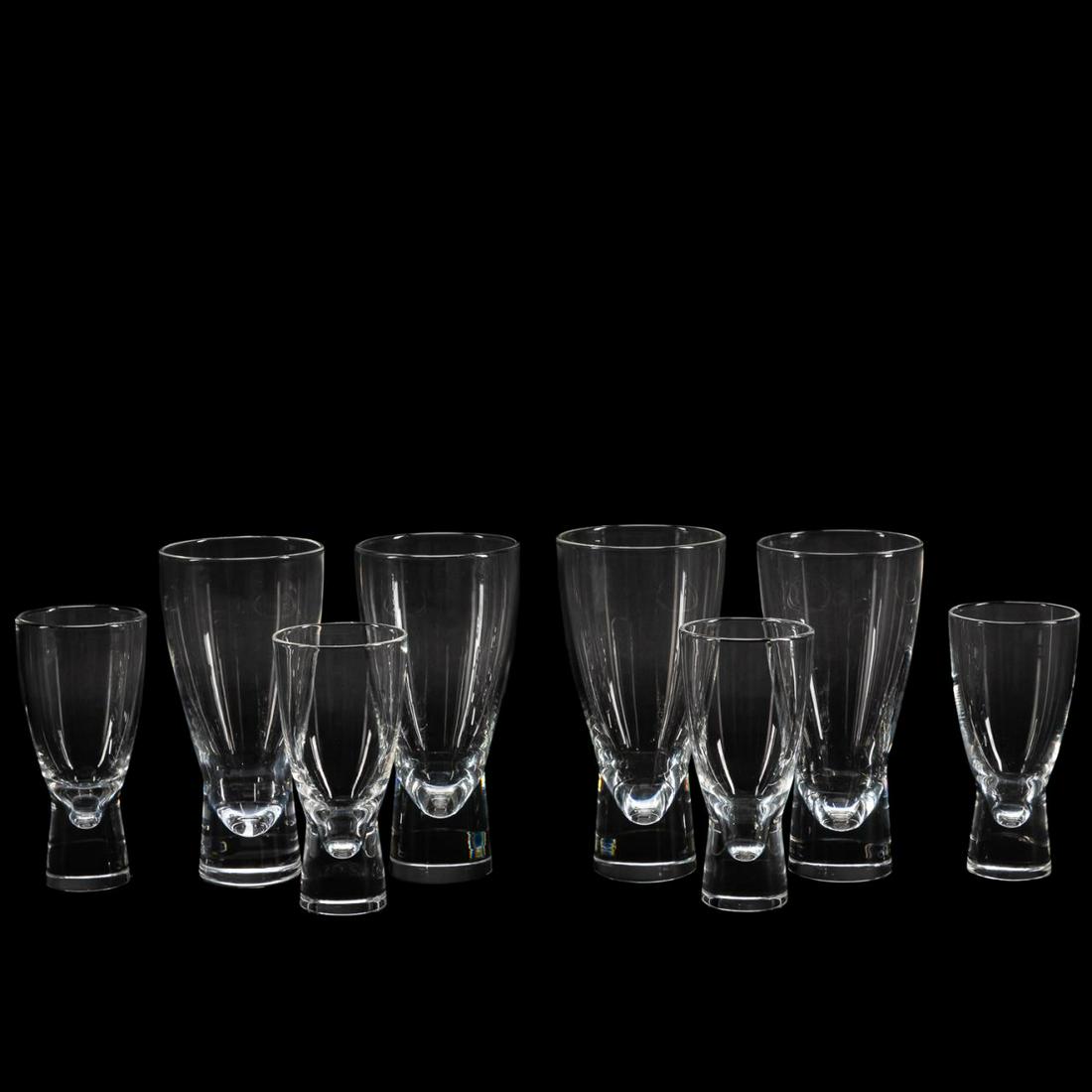 8 STEUBEN COLORLESS HIGHBALL & WINE GLASSES: Steuben (American), late 20th century. Eight colorless crystal highball and wine glasses in an hourglass shape. Designed by Donald Pollard in 1953. Approx. h. 6.5" (tallest), h. 5.25" (shortest).