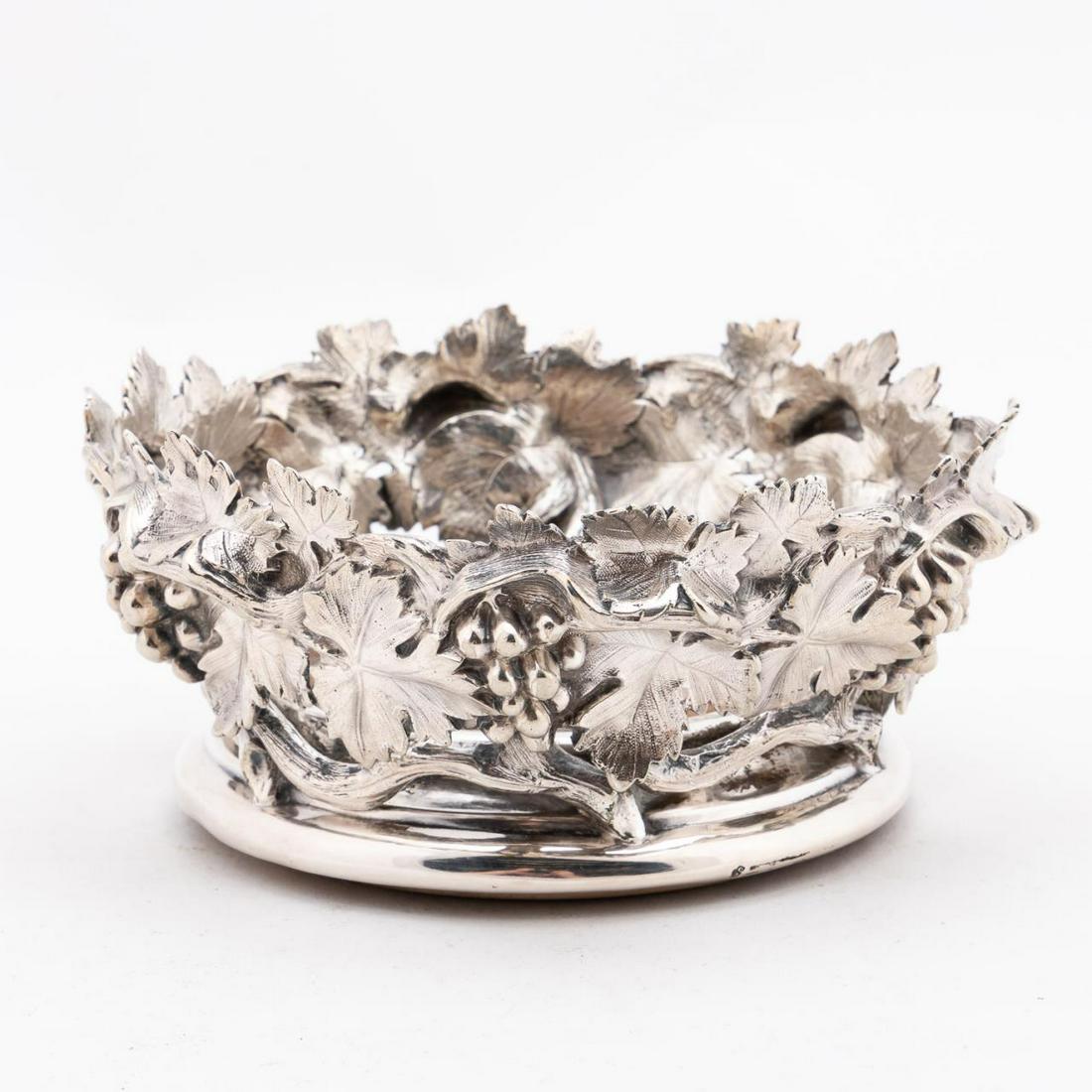19th C ENGLISH GRAPEVINE SILVERPLATE WINE COASTER: British, 19th century. Silverplate grape vine form wine coaster with wooden bottom. Marked "S". Approx. h. 3.25", dia. 6.75"