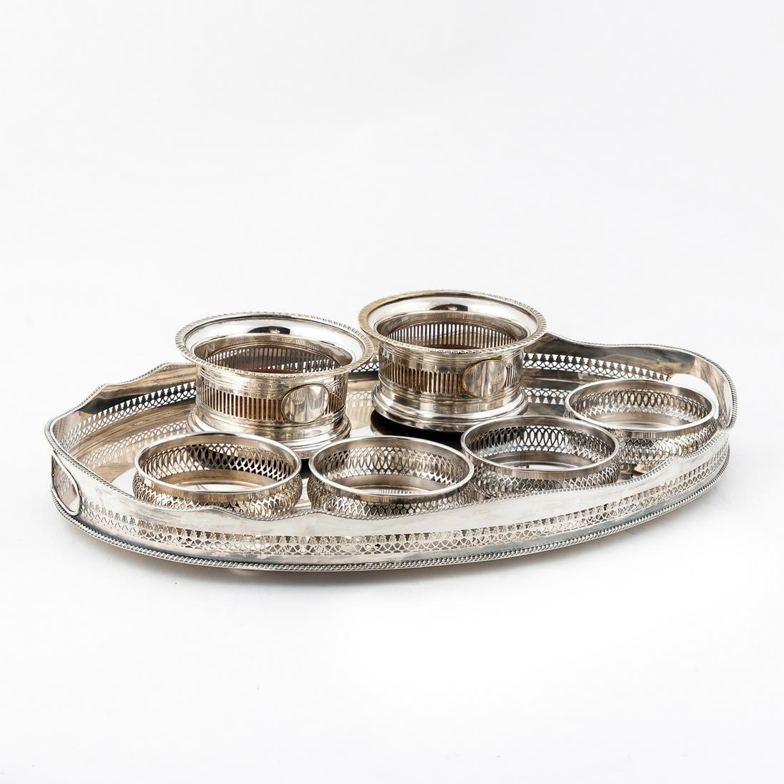 7 PCS, SILVERPLATE GALLERY TRAY & WINE COASTERS: American and British, 20th century. Group of seven silverplate table articles comprising two unmarked tall wine bottle coasters with wooden bottoms (h.3.25", w. 6.25"), four Crescent Silverware wine c