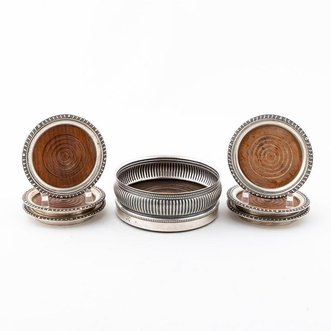 7 PCS, STERLING SILVER COASTERS & WINE COASTER: Gorham and American, 20th century. Gorham silverplate bottle coaster and six sterling rimmed coasters marked "sterling" only. Approx. dia. 5" (bottle coaster), dia. 3.75" (coasters)