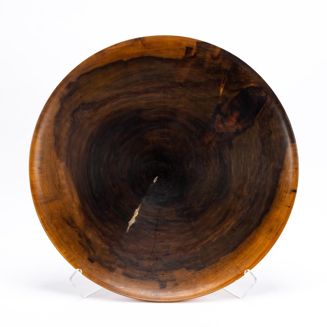 ED MOULTHROP, FIGURED TULIPWOOD CHARGER WITH STAND: Ed Moulthrop (American/Georgia, 1916-2003). Turned burl wood charger of figured tulipwood with clear lacquer finish. Signed and inscribed underneath with type of wood, with lucite stand. Approx. h.3",