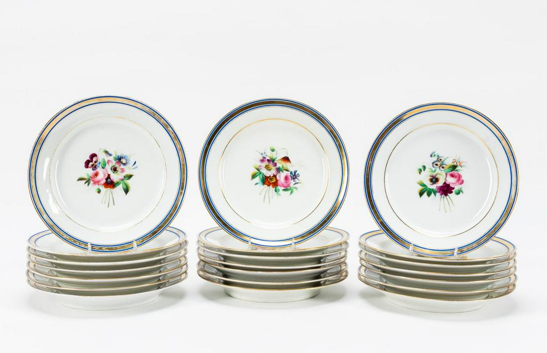 SET OF 21 FLORAL PARIS PORCELAIN DINNER PLATES: French, 19th century. Set of twenty-one Paris porcelain dinner plates, having cobalt blue and gilded banded rims encircling a polychrome floral spray. Unmarked. Approx. of one, dia. 9.25".