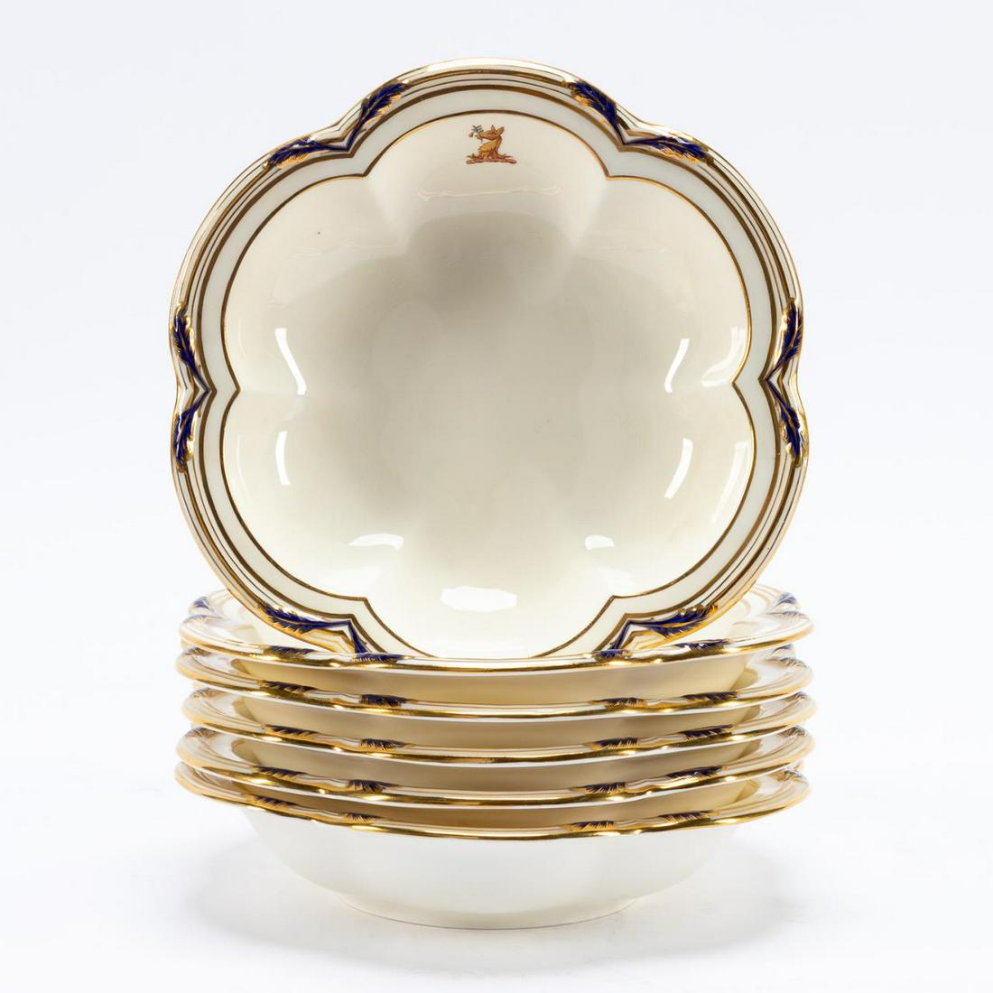 SET 6, MINTON TIFFANY & CO. ARMORIAL SOUP BOWLS: Minton (English) retailed by Tiffany & Co. (American), 20th century. Set of six armorial bone china "Baccleuch" rim soup bowls, having a lobed-form with cobalt leaves and gilt trim, and crest depictin