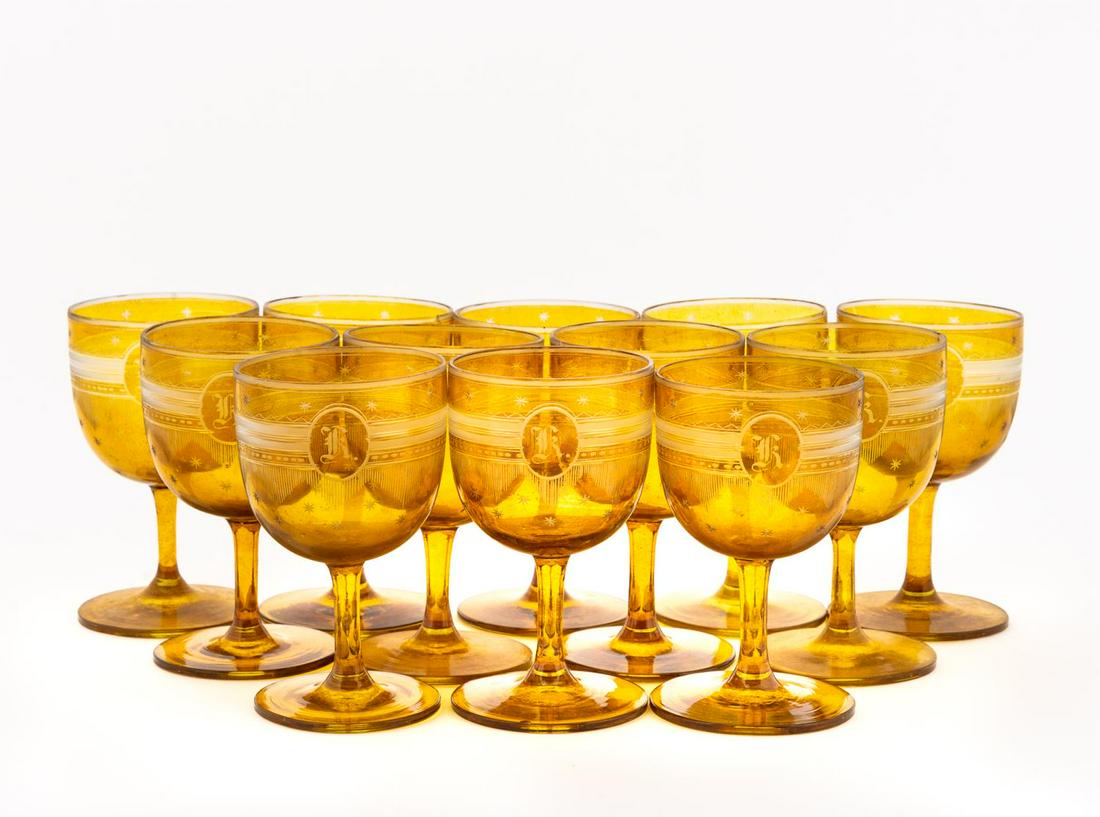 MONOGRAMMED AMBER GLASS STEMWARE, 12PCS: American or European, late 19th to early 20th century. Set of twelve amber glass wine glasses, all with needle etched decoration and monogrammed "K". Unmarked. Approx. of one, h. 4.5", dia. 2.5".