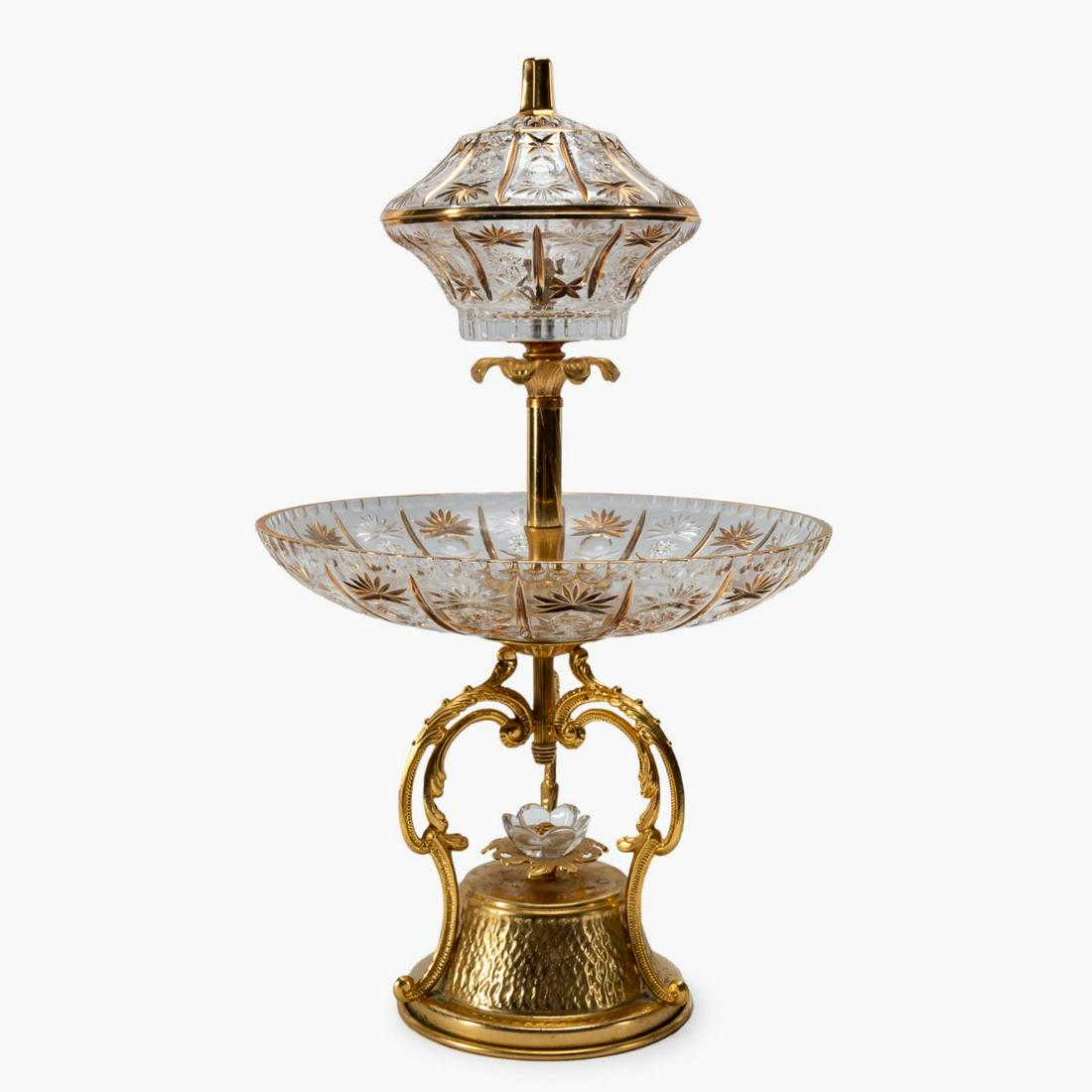 TWO-TIER CRYSTAL AND GILT-METAL SERVER: Likely American, third-quarter 20th century. Molded crystal two-tier server, having a covered upper bowl, and scrolled gilt-metal base. Unmarked. Approx. h. 22", dia. 13"