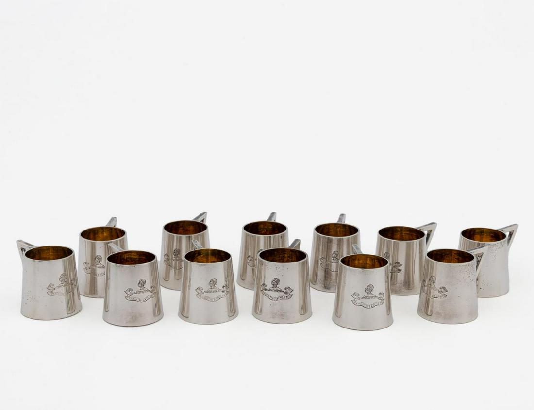 SET OF 12, GIBSON & LANGMAN STERLING TOTS, 1897: William Gibson and John Langman (English, late 19th/early 20th century). Set of twelve sterling silver tots with gold wash interiors and engraved with bust and banner reading "Virtutis Amore". Bearing