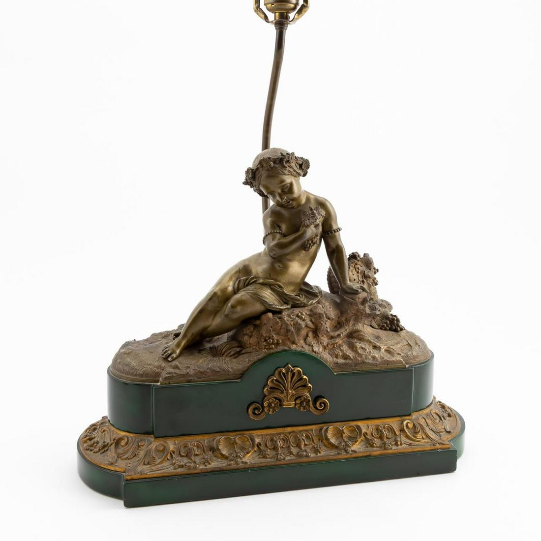 GILT BRONZE FEMALE NUDE FIGURAL TABLE LAMP: Continental, early 20th century. Figural table lamp of gilt bronze having a reclining nude with grapes, on green laminated wood base. Apparently unmarked. Approx. h. 20" to top of socket, w. 15.75"
