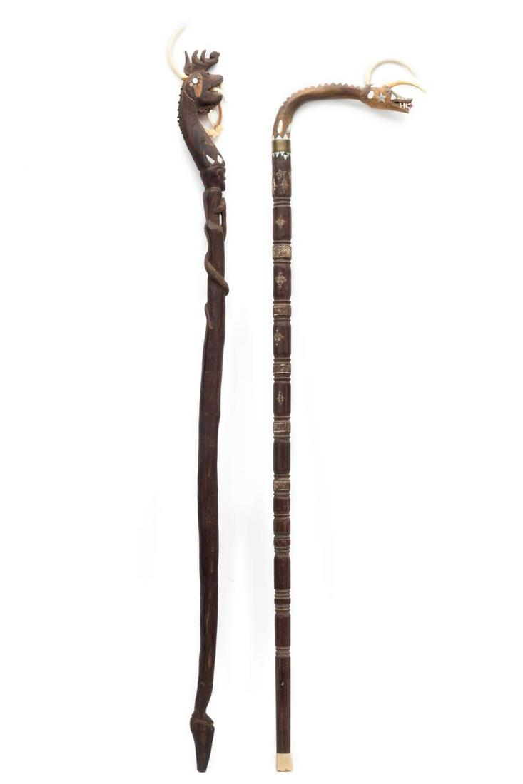 (2) PACIFIC ISLAND HAND CARVED DRAGON CANES: (2) Pacific Island hand carved dragon canes, likely Dayak or Iban, having dragon heads with tusks set into the tops, open mouths with teeth, bodies inlaid with mother of pearl and rubbed with kaolin, 
