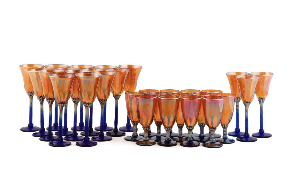STRINI GOLD & BLUE LUSTER ART GLASS STEMWARE, 30PC: Robert "Rick" Strini (American b. 1942), thirty piece set of art glass stemware, each piece having a gold luster flared bowl, on cobalt blue twist stem, and spreading foot, comprising: fourteen goblet