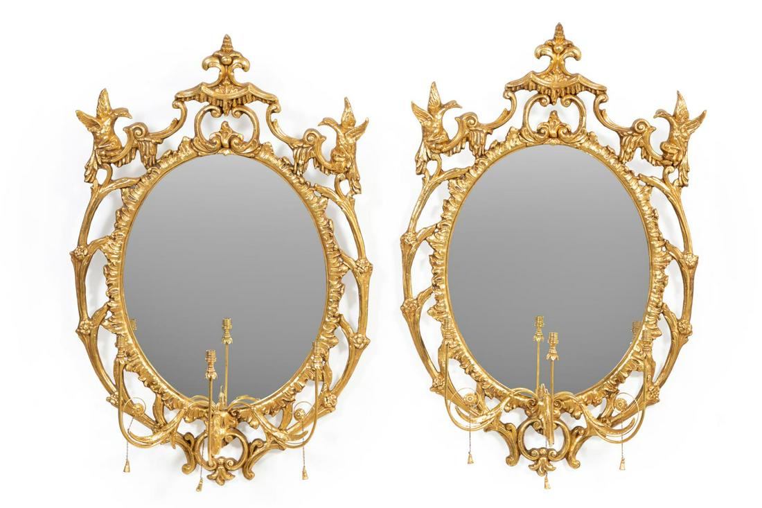 PAIR OF CHINESE CHIPPENDALE STYLE GILTWOOD MIRRORS: Pair of Chinese Chippendale style giltwood girandole mirrors, of oval form, the double giltwood frames, each having a crest with a stylized pagoda flanked by Ho Ho birds, surmounting a beveled oval mi