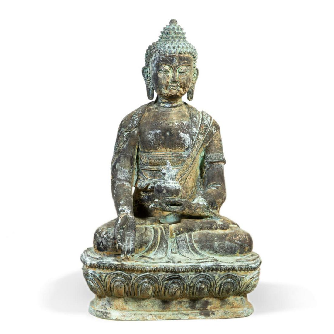 MONUMENTAL PATINATED METAL SEATED MEDICINE BUDDHA: Monumental patinated metal and parcel gilt seated Medicine Buddha, depicted wearing a robe with incised gilt floral decoration, holding a vessel with a plant in one hand and having the other across th