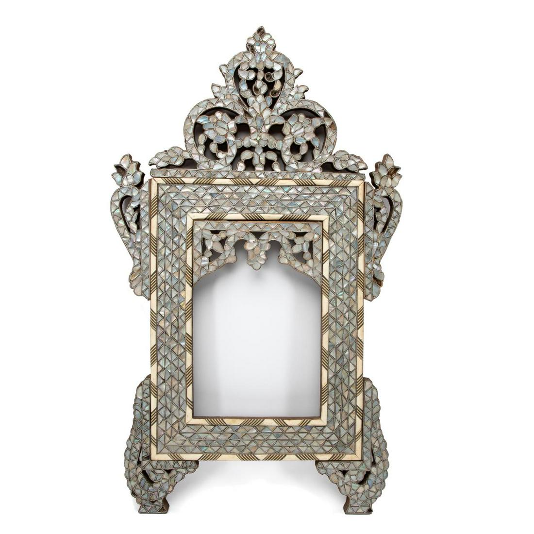 SYRIAN MOTHER OF PEARL & BONE INLAID FRAME: Middle Eastern, likely Syrian, inlaid small wall mirror frame, having a scrolled, pierced crest and ears, with mother of pearl and bone inlay, apparently unmarked. Approx. h. 27", w. 16.25", rabbet h.