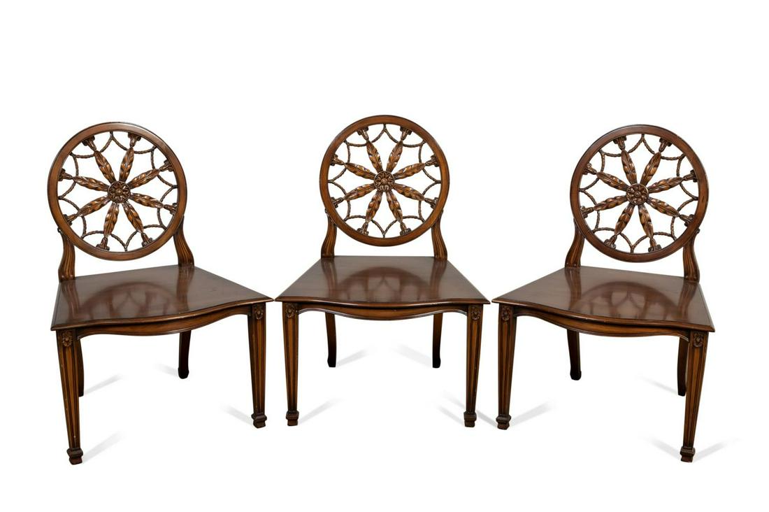 THREE SMITH & WATSON HEPPLEWHITE WHEELBACK CHAIRS: Smith & Watson (American, founded 1907), set of three mahogany wheelback hall chairs in the Hepplewhite taste, each having a foliate pierced splat, plank seat, and rising on front fluted tapering legs