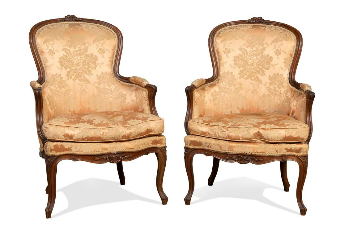 PAIR OF PROVINCIAL LOUIS XV STYLE PEACH BERGERES: Pair of Louis XV Provincial style peach upholstered bergeres, each having a high domed back, closed partially padded arms, joined silk damask cushioned seat, and rising on cabriole legs, apparently un