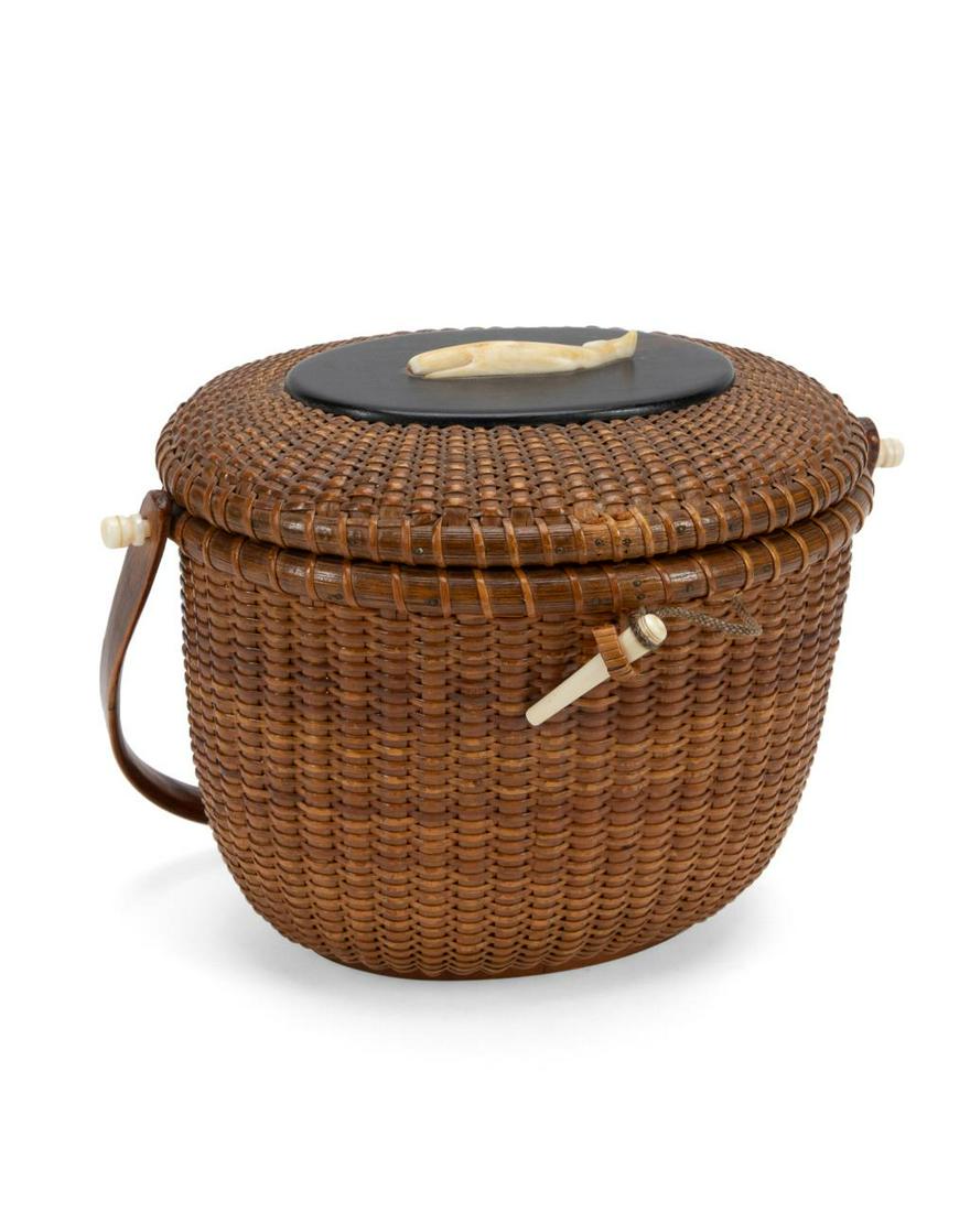 JOSE FORMOSO REYES NANTUCKET WHALE HANDLED BASKET: Jose Formoso Reyes (American 1902-1980), woven wood and rattan friendship basket having a dark wood carved medallion with bone whale, signed and marked "Made in Nantucket" to underside. Provenance: Fr
