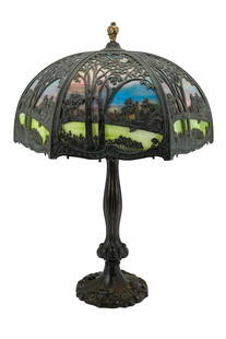 TABLE LAMP WITH HANDEL SCENIC SLAG GLASS SHADE: Handel Lamp Company (American 1885-1941) patinated metal shade and lamp, first quarter 20th century, the frame having a lake or pond landscape with curved slag glass panels, on a scrolled patterned ba