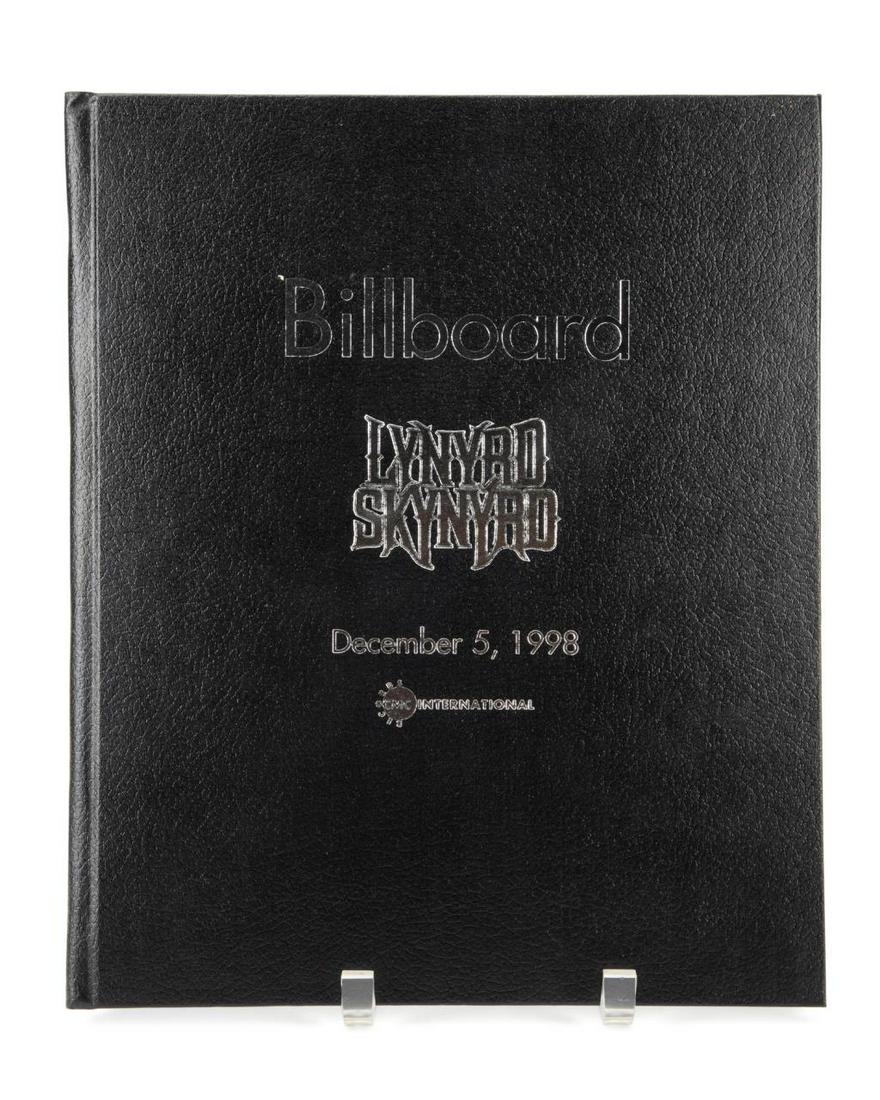 BILLBOARD COMMEMORATIVE TRIBUTE TO LYNYRD SKYNRD: Various authors, "Billboard: Commemorative Tribute to Lynyrd Skynrd", published by Billboard Magazine, various cities, December 5, 1998, folio, hardcover book, black board covers. Provenance: From the