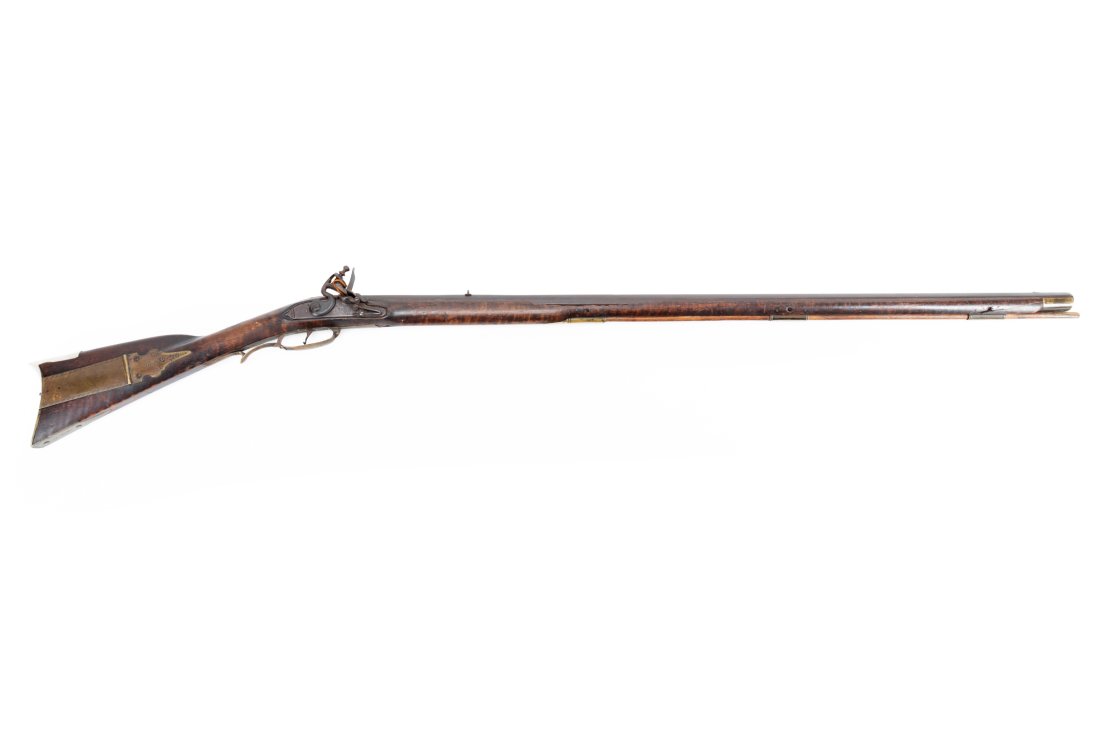 AMERICAN TIGER MAPLE PERCUSSION LONG RIFLE: American antique flintlock Kentucky long rifle, 18th / 19th century, having a tiger maple stock, octagonal barrel, brass furniture, cheek rest, shaped silver inlay, single trigger, carved foliate desi